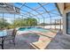 This in-ground pool and patio are screened in and offer beautiful backyard views at 13100 Lakewind Dr, Clermont, FL 34711