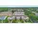 An aerial view shows townhomes in a community surrounded by lush green trees and manicured lawns at 14421 Vashons Way, Winter Garden, FL 34787