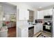 Open kitchen view leading to the living area, featuring stainless appliances and white cabinets at 14421 Vashons Way, Winter Garden, FL 34787