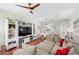 Spacious living room featuring a large sectional sofa, hardwood floors, and an entertainment center at 14421 Vashons Way, Winter Garden, FL 34787