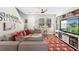 Comfortable living room with a large sectional sofa, hardwood floors, and natural light from the windows at 14421 Vashons Way, Winter Garden, FL 34787