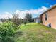 Expansive backyard featuring a lush lawn, mature trees, and the exterior of a well-maintained home at 1454 Westbury Dr, Clermont, FL 34711