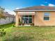 Charming backyard with a covered patio area, well-maintained lawn, and view of the home's exterior at 1454 Westbury Dr, Clermont, FL 34711
