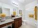 Well-lit bathroom equipped with a granite countertop vanity, framed mirror, and a glass-enclosed shower at 1454 Westbury Dr, Clermont, FL 34711