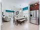 Open-concept dining room with white table, bench seating, and stainless steel refrigerator at 1454 Westbury Dr, Clermont, FL 34711