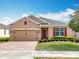 Charming single-story home with brick-paved driveway, manicured lawn, and a welcoming red front door at 1454 Westbury Dr, Clermont, FL 34711