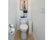 Small half-bathroom with tile floor, toilet, and small decor at 1454 Westbury Dr, Clermont, FL 34711