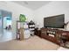 Bright living room featuring a large television, stylish furniture, and an open doorway to the dining area at 1454 Westbury Dr, Clermont, FL 34711