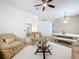 Comfortable living space with plush seating, ceiling fan, glass coffee table, and view into dining area at 1454 Westbury Dr, Clermont, FL 34711