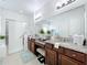Well-lit main bathroom with double vanity, granite countertops, and glass-enclosed shower at 1454 Westbury Dr, Clermont, FL 34711