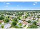 Wide aerial view of a sprawling residential community with lush greenery, trees, and a golf course backdrop at 1514 Vandam St, The Villages, FL 32162