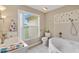 Bathroom with soaking tub, decorative tile, and natural light at 1514 Vandam St, The Villages, FL 32162