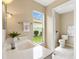 Bright bathroom featuring a white sink, modern fixtures, and a view of the garden at 1514 Vandam St, The Villages, FL 32162