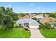 Beautiful single-story home featuring a well-manicured lawn, garden beds and a brick driveway at 1514 Vandam St, The Villages, FL 32162