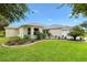 Attractive single-story home with green lawn and garden, showcasing inviting curb appeal at 1514 Vandam St, The Villages, FL 32162