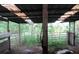 Barn interior featuring an aging wooden roof, worn supports, with outdoor access and greenery at 15587 Se 150Th Ave, Weirsdale, FL 32195