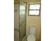 Bathroom featuring a shower stall, toilet, and window at 15587 Se 150Th Ave, Weirsdale, FL 32195