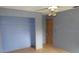 Gray bedroom featuring an empty closet space, ceiling fan and a door at 15587 Se 150Th Ave, Weirsdale, FL 32195