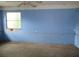 Bedroom features blue walls, a single window, and a ceiling fan, providing potential for renovation and personalization at 15587 Se 150Th Ave, Weirsdale, FL 32195
