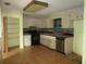 Functional kitchen with white cabinets, a black range, and tile floors, ready for an update at 15587 Se 150Th Ave, Weirsdale, FL 32195