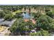 Gorgeous aerial view of the home and neighborhood featuring lush trees and a serene pond with a fountain at 15837 Hidden Lake Cir, Clermont, FL 34711