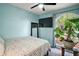 A bedroom with light blue walls, a ceiling fan, and a large window with a green view at 15837 Hidden Lake Cir, Clermont, FL 34711