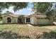 Charming single-story home with a well-manicured lawn, mature trees, and attached two-car garage at 15837 Hidden Lake Cir, Clermont, FL 34711