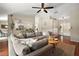 Open concept living room with hardwood floors, stylish furniture and view into the kitchen at 15837 Hidden Lake Cir, Clermont, FL 34711
