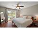 Spacious primary bedroom with hardwood floors, a ceiling fan, and access to the pool area at 15837 Hidden Lake Cir, Clermont, FL 34711