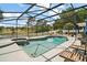 Backyard pool and spa with lake view, featuring a screened enclosure and plenty of seating at 15837 Hidden Lake Cir, Clermont, FL 34711