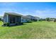 A spacious backyard with lush green grass, with a view of neighboring homes at 17112 Goldcrest Loop, Clermont, FL 34714
