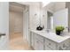 Bright bathroom with white vanity, decorative mirror, and tiled floor at 17112 Goldcrest Loop, Clermont, FL 34714