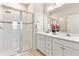 Modern bathroom with glass-enclosed shower and double vanity with decorative flowers at 17112 Goldcrest Loop, Clermont, FL 34714
