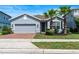 Charming single-story home with a well-manicured lawn and inviting curb appeal with palm trees at 17112 Goldcrest Loop, Clermont, FL 34714