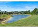 Scenic pond view surrounded by lush greenery and residential homes, offering a serene setting at 17112 Goldcrest Loop, Clermont, FL 34714