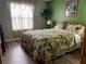 Relaxing bedroom with a patterned comforter, sheer curtains, and natural light at 1723 Banberry Run, The Villages, FL 32162