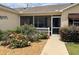 Welcoming screened front porch surrounded by mature landscaping and colorful rose bushes at 1723 Banberry Run, The Villages, FL 32162
