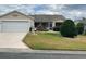 Inviting single-story home with attached garage, manicured lawn, and colorful rose bushes at 1723 Banberry Run, The Villages, FL 32162