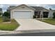 Charming single-story home featuring a spacious driveway, two-car garage, and well-maintained landscaping at 1723 Banberry Run, The Villages, FL 32162