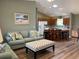 Open-concept living room flows into kitchen with bar seating and wood-look flooring at 1723 Banberry Run, The Villages, FL 32162