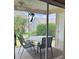 Enclosed patio with table and chairs overlooking backyard at 1723 Banberry Run, The Villages, FL 32162