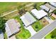Overhead view of home with awnings, palm tree, green lawn, and driveway at 1726 W Schwartz Blvd, Lady Lake, FL 32159