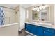 Bathroom with dual sinks, blue vanity, and shower with sliding door at 1726 W Schwartz Blvd, Lady Lake, FL 32159