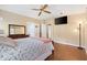Bedroom with hardwood floors, ceiling fan, television, and ensuite bath at 1726 W Schwartz Blvd, Lady Lake, FL 32159