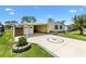 Charming single-story home with a well-manicured lawn and decorative palm tree design on the driveway at 1726 W Schwartz Blvd, Lady Lake, FL 32159