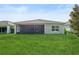 A spacious backyard featuring a well maintained lawn and a screened in porch at 185 Hamlet Loop, Davenport, FL 33837