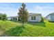 A well-maintained backyard features a lush lawn, mature trees, and a view of the home's exterior at 185 Hamlet Loop, Davenport, FL 33837