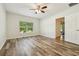 Spacious bedroom with ceiling fan, wood-look flooring, and a view of the backyard at 185 Hamlet Loop, Davenport, FL 33837