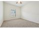 Bedroom with neutral carpet, ceiling fan, and large window providing natural light at 185 Hamlet Loop, Davenport, FL 33837