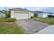 Charming single Gathering home with a brick paved driveway and an attached two car garage at 185 Hamlet Loop, Davenport, FL 33837